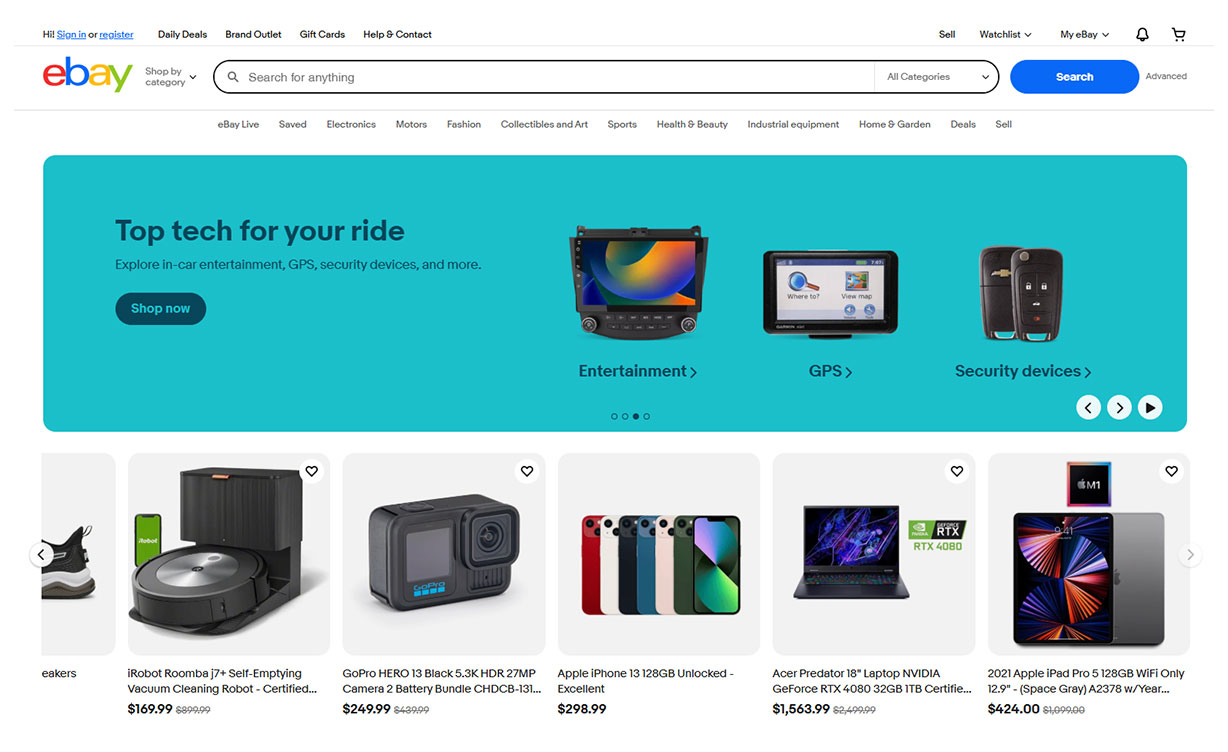 Screenshot of eBay's homepage featuring a banner for in-car electronics including entertainment systems, GPS devices, and security products, with refurbished and used product listings below