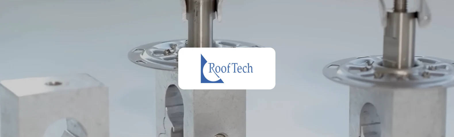 Produktaufnahme von drei Edelstahl-Montageelementen für Dachbefestigungen vor hellgrauem Hintergrund, mit dem RoofTech-Logo im Vordergrund - ein Hinweis auf die Xentral-Kundenreferenz RoofTech.