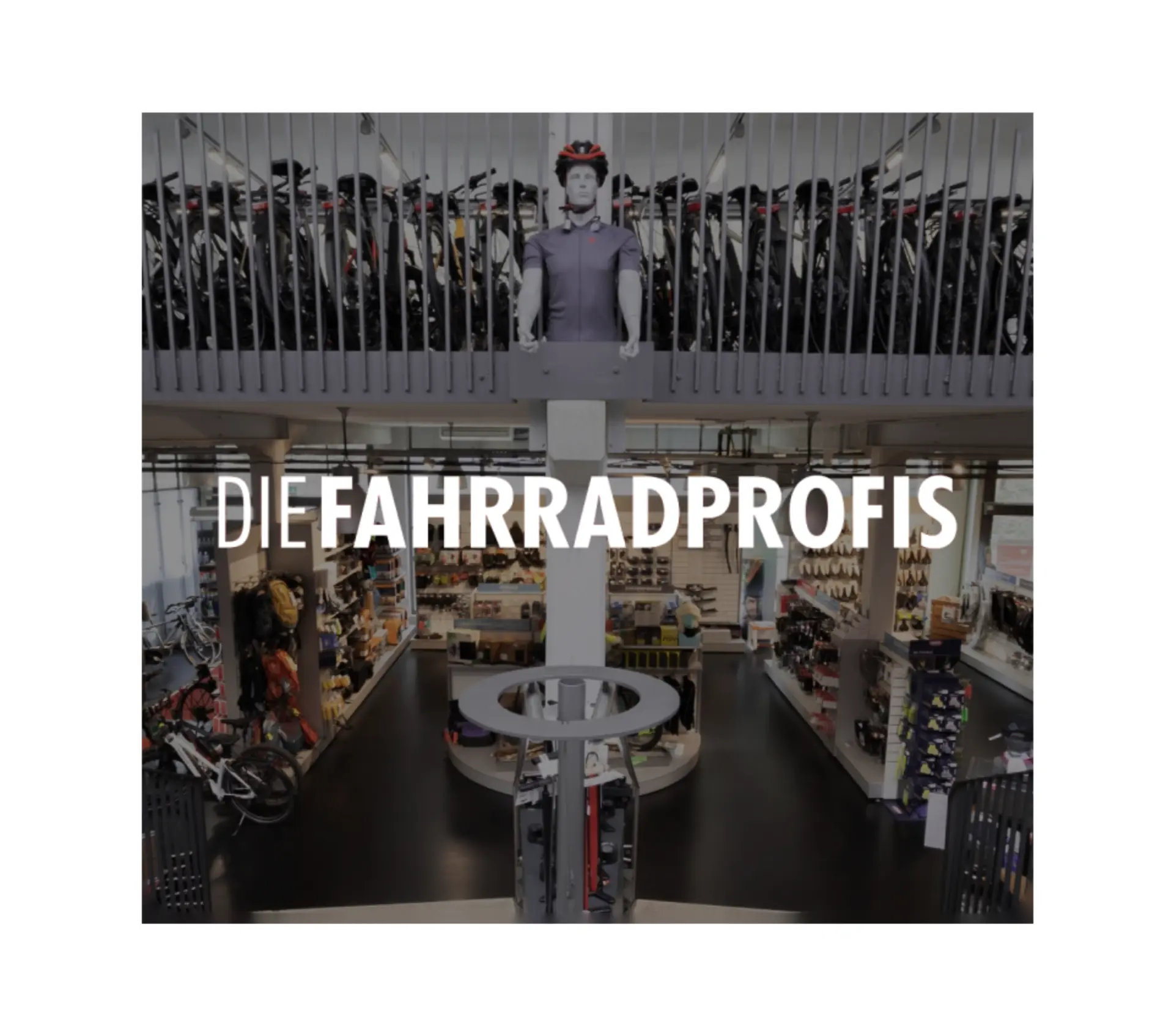 Xentral ERP for bike retail: High-angle interior view of a large two-story bicycle shop with the white text overlay "DIE FAHRRADPROFIS". The ground floor features retail displays, while the upper level shows a long row of bikes.