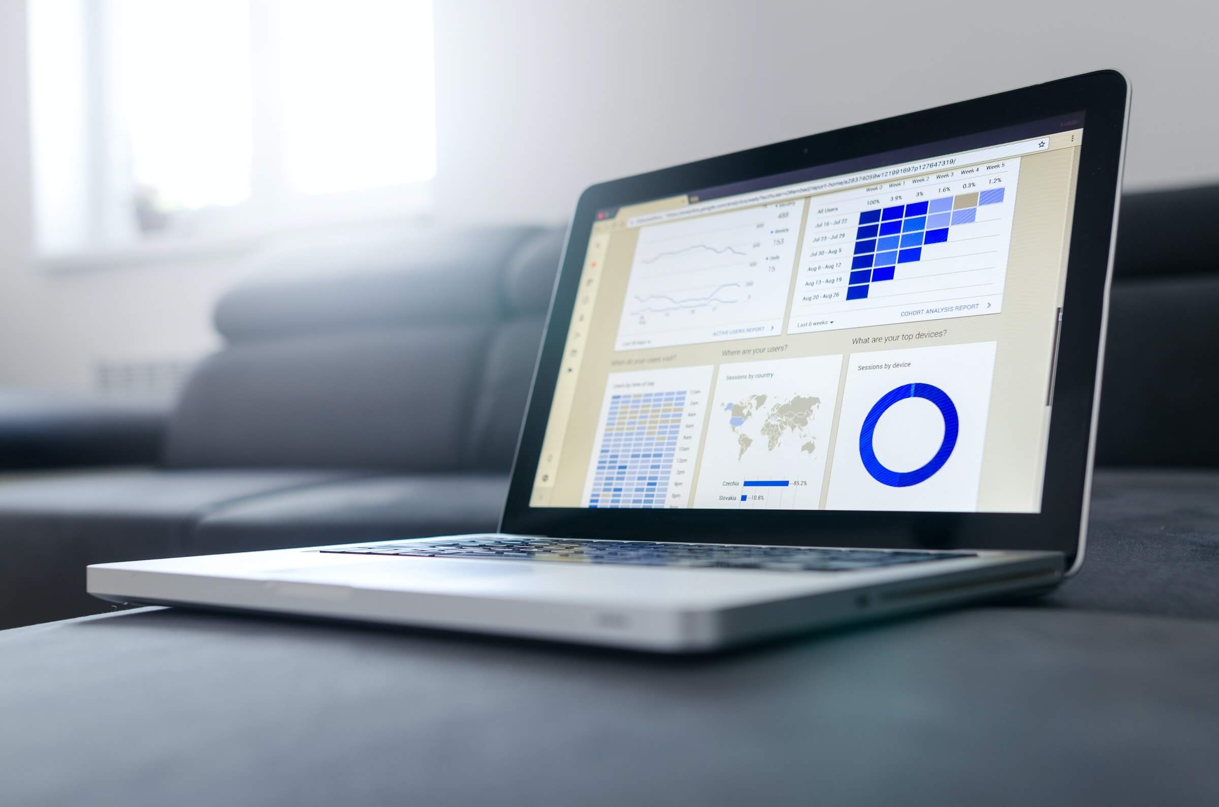 Laptop mit Bestandsverwaltungssoftware zeigt Daten-Diagramme und Weltkarte.