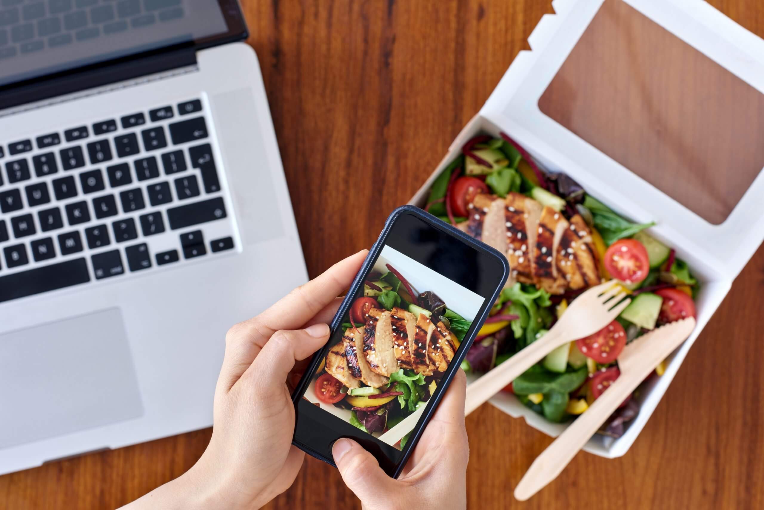 Smartphone photographing fresh salad for e-commerce food industry article.